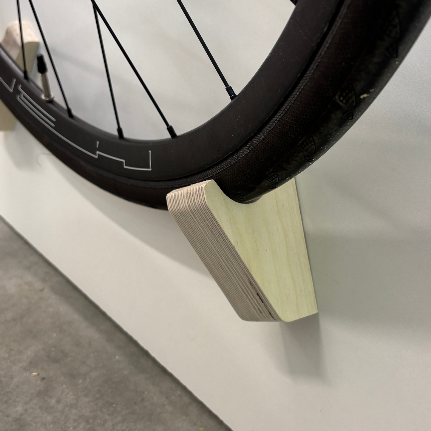 Support vélo mural design – Bois massif ou contreplaqué de merisier, accroche par roues et cadre, angle 15–20°, vis et ancrages inclus