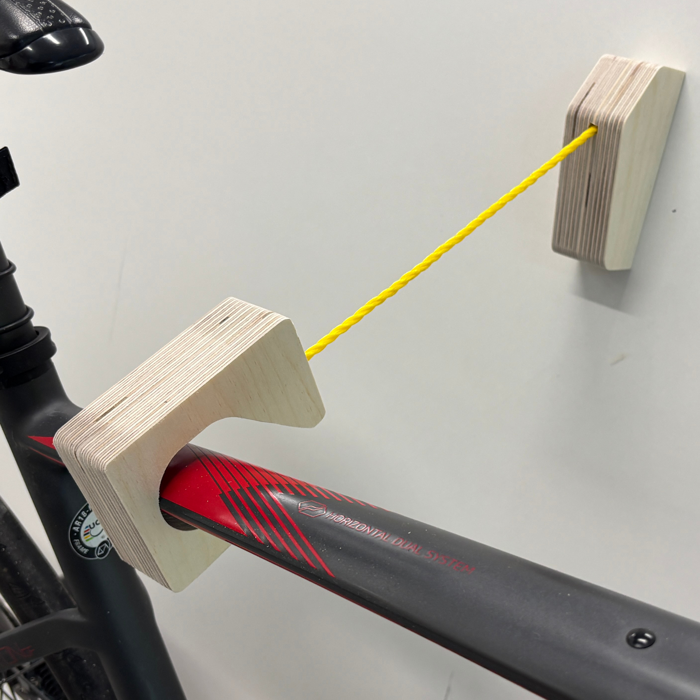 Support vélo mural design – Bois massif ou contreplaqué de merisier, accroche par roues et cadre, angle 15–20°, vis et ancrages inclus